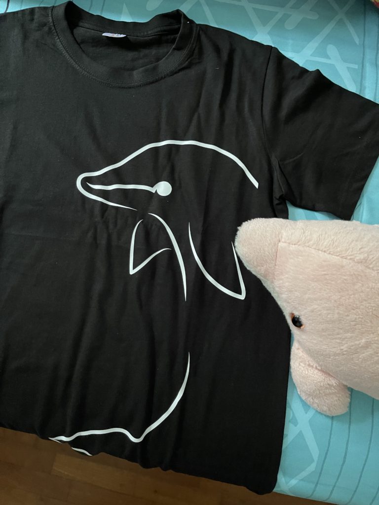 Black shirt with a minimalist design of a dolphin printed on the right side of the shirt